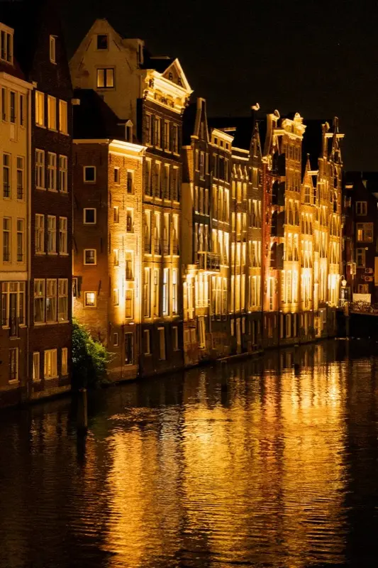 Amsterdam Canal Houses Night Reflection con conectividad HelloRoam eSIM para viajeros de todo el mundo