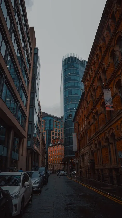 Manchester city centre at night with the Beetham Tower lit up against a cloudy sky