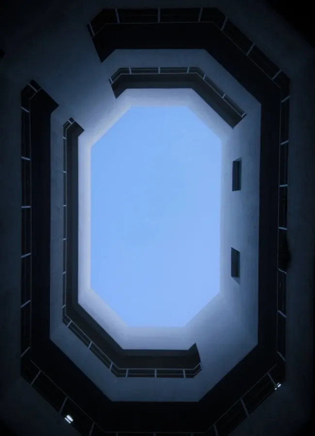 Sohar fort vid havet med blå himmel och moderna containerhamnen synlig i bakgrunden