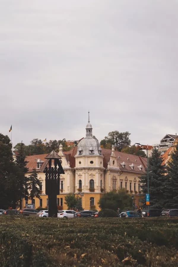 Plaza del Consejo de Brașov, Rumanía, con los Cárpatos al fondo y plan eSIM de HelloRoam para viajeros
