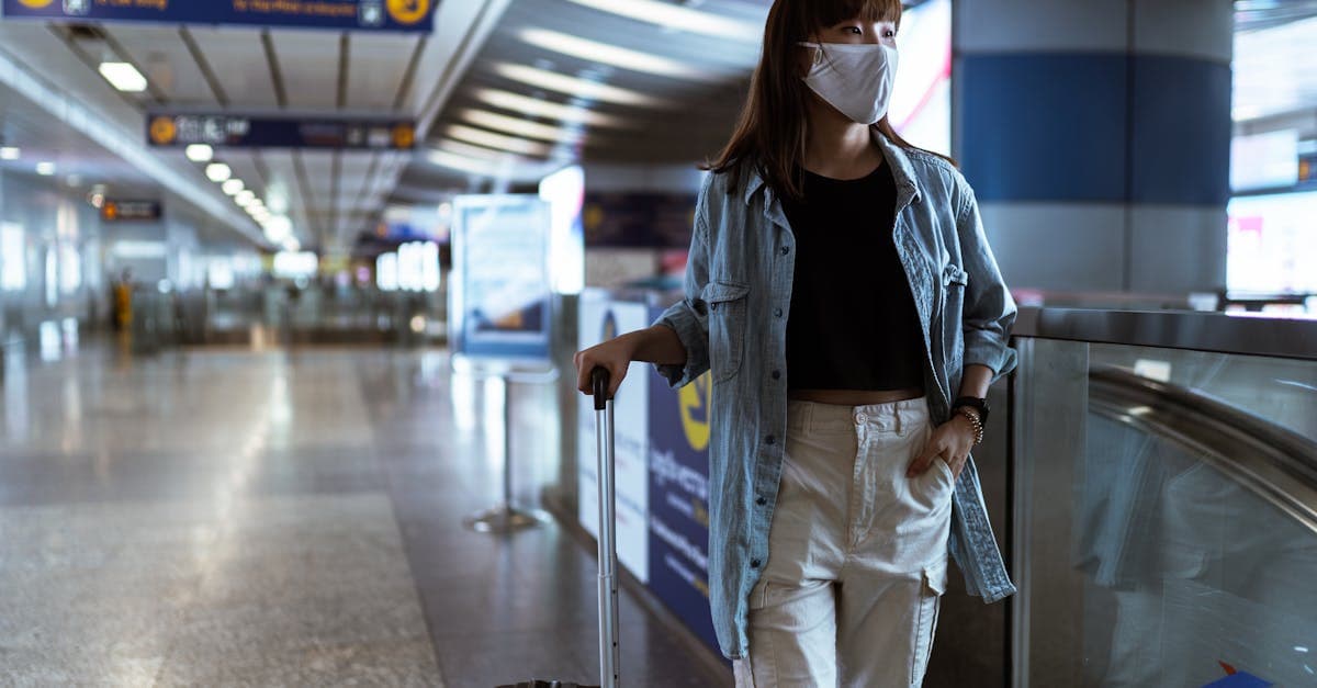Woman with luggage at airport terminal reviewing her pre-departure safety checklist for travelling solo