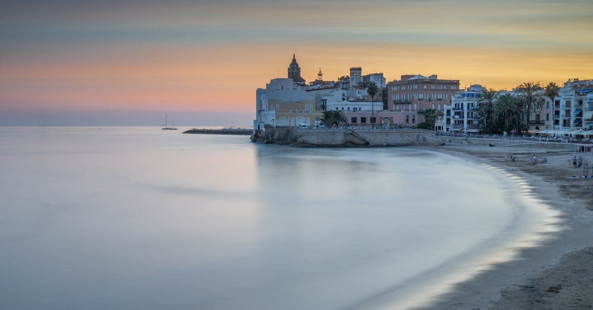 Sitges strand och stadssiluett i skymning – en guide till vad resa till Spanien en vecka kostar.