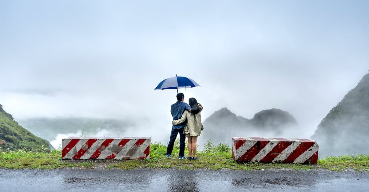 Cặp đôi đứng trên vách đá trong sương mù, so sánh các gói bảo hiểm du lịch tốt nhất 2026