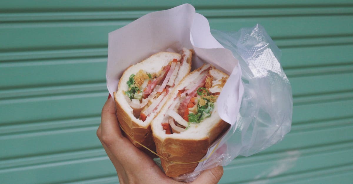 Fresh bánh mì sandwich held in hand at a street food Vietnam stall in Ho Chi Minh City