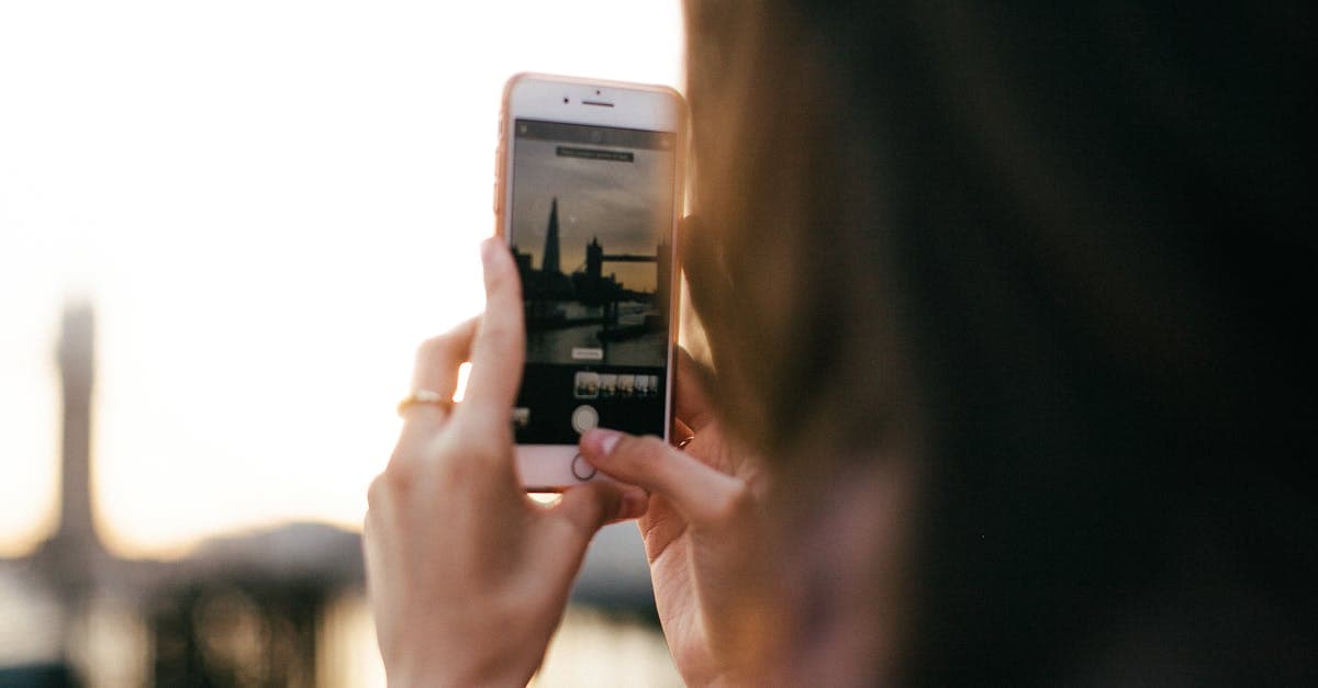 Woman using a smartphone at sunset in London, preparing a travel eSIM and mobile data for her US trip