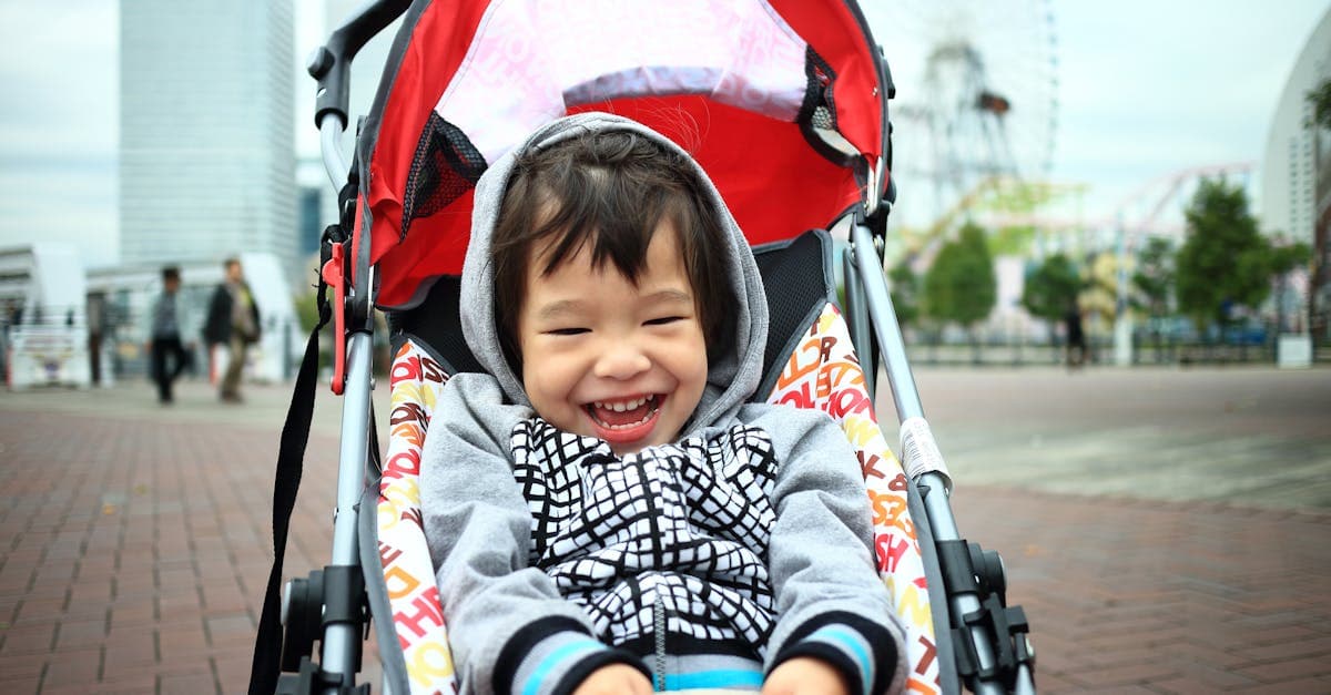Smiling toddler seated comfortably in a travel stroller enjoying a visit to a Yokohama urban park