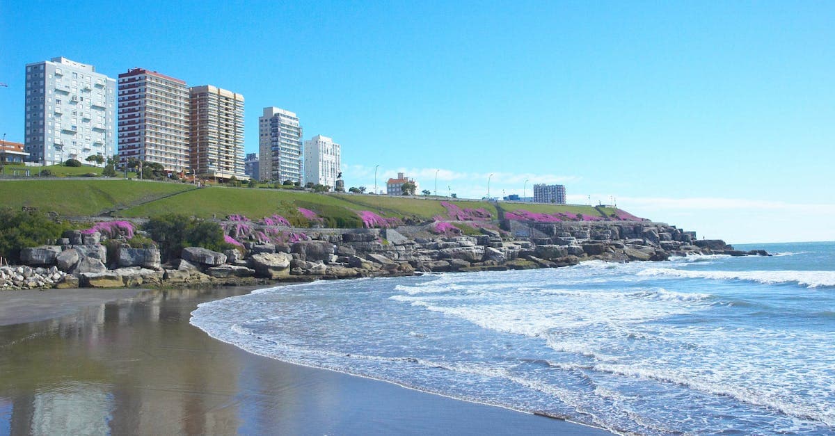 Vista da orla de Mar del Plata com ondas quebrando na praia e o horizonte da cidade ao fundo