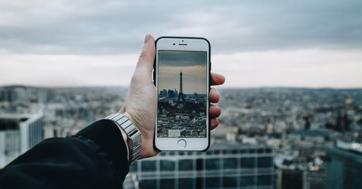 Person fotografiert den Eiffelturm mit dem Smartphone und vergleicht mobile Internetkosten im Ausland