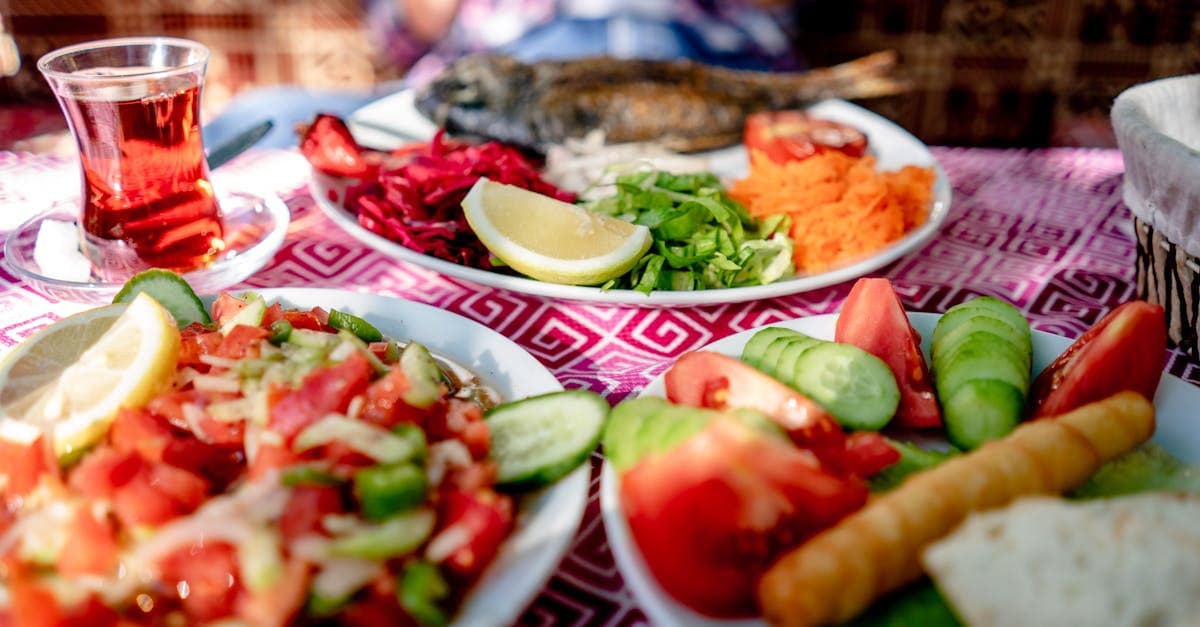 Śródziemnomorski posiłek z grillowaną rybą, świeżą sałatką i herbatą na stoliku restauracyjnym w Turcji