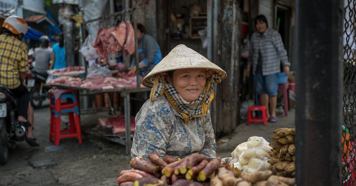Smiling Vietnamese vendor selling fresh vegetables at a Ho Chi Minh City outdoor market