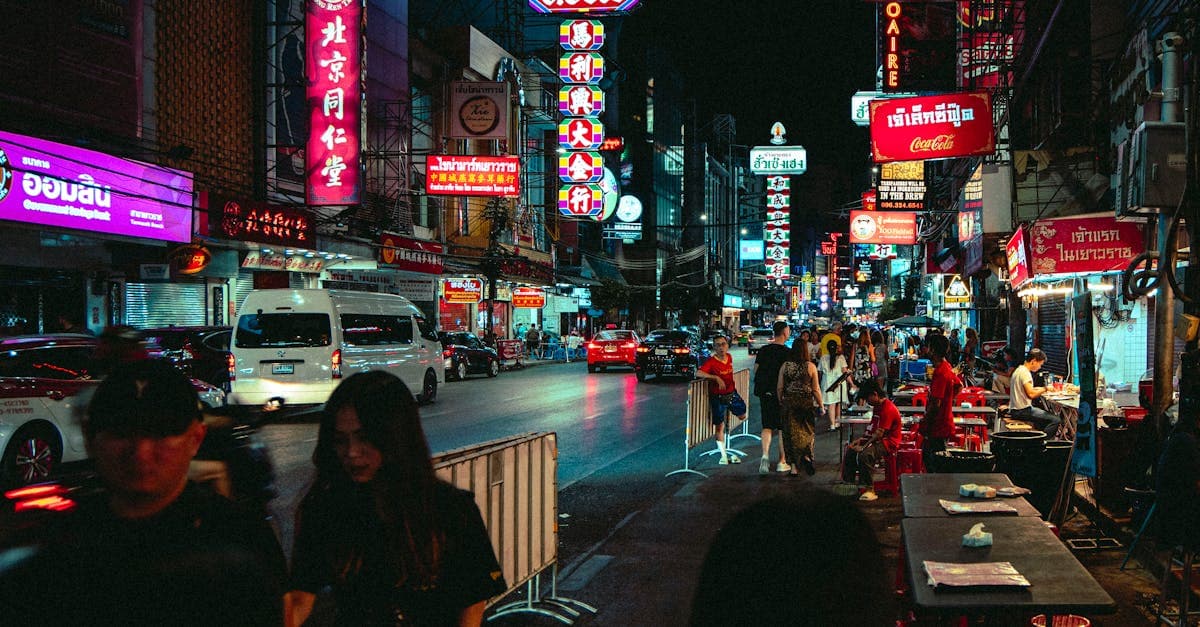Kleurrijke neonlichten en straatverkopers in de Chinatown van Bangkok, ideaal om bereikbaar te blijven in Thailand.