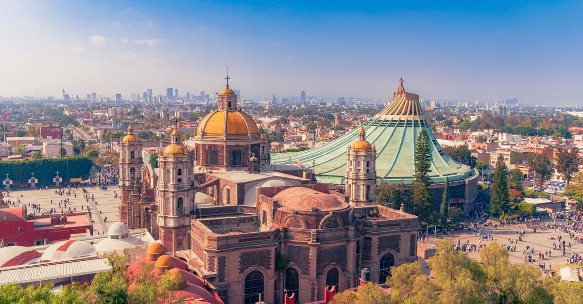 Panorama sanktuarium w Guadalupe z zabytkową bazyliką, nowoczesną świątynią i placem pełnym pielgrzymów.