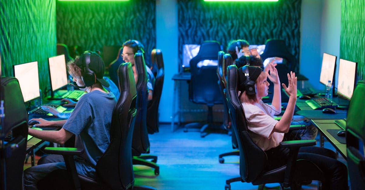 Group of people using computers with green lighting at an internet cafe, highlighting shared network security risks