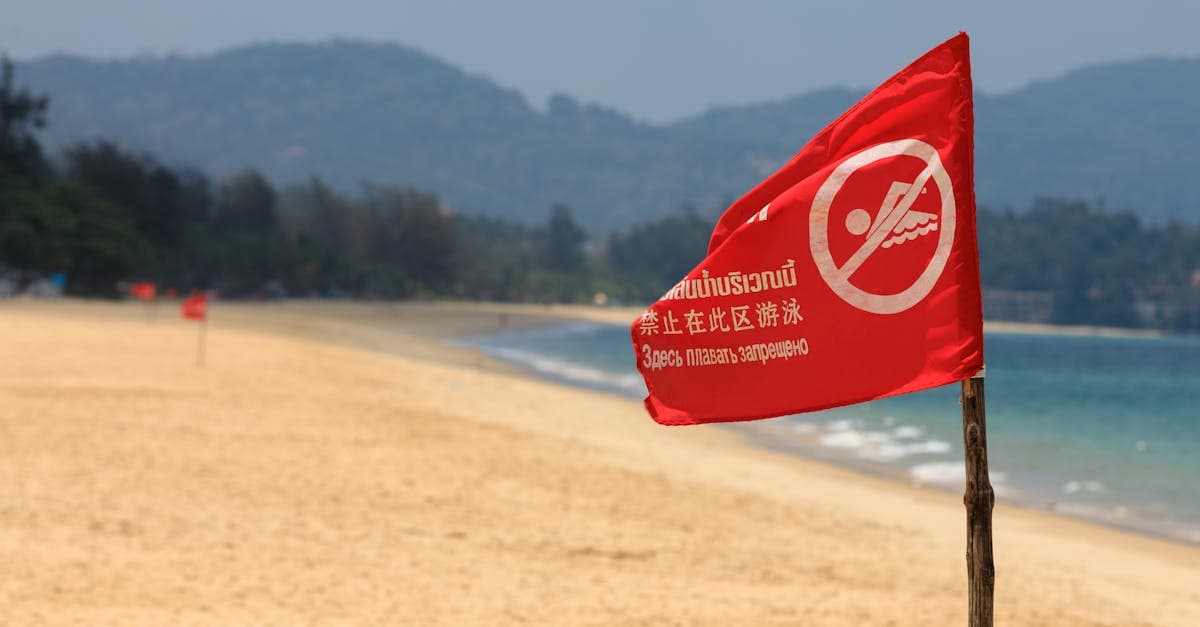 Red warning flag on a sandy Thai beach prohibiting swimming, an essential safety signal for visitors