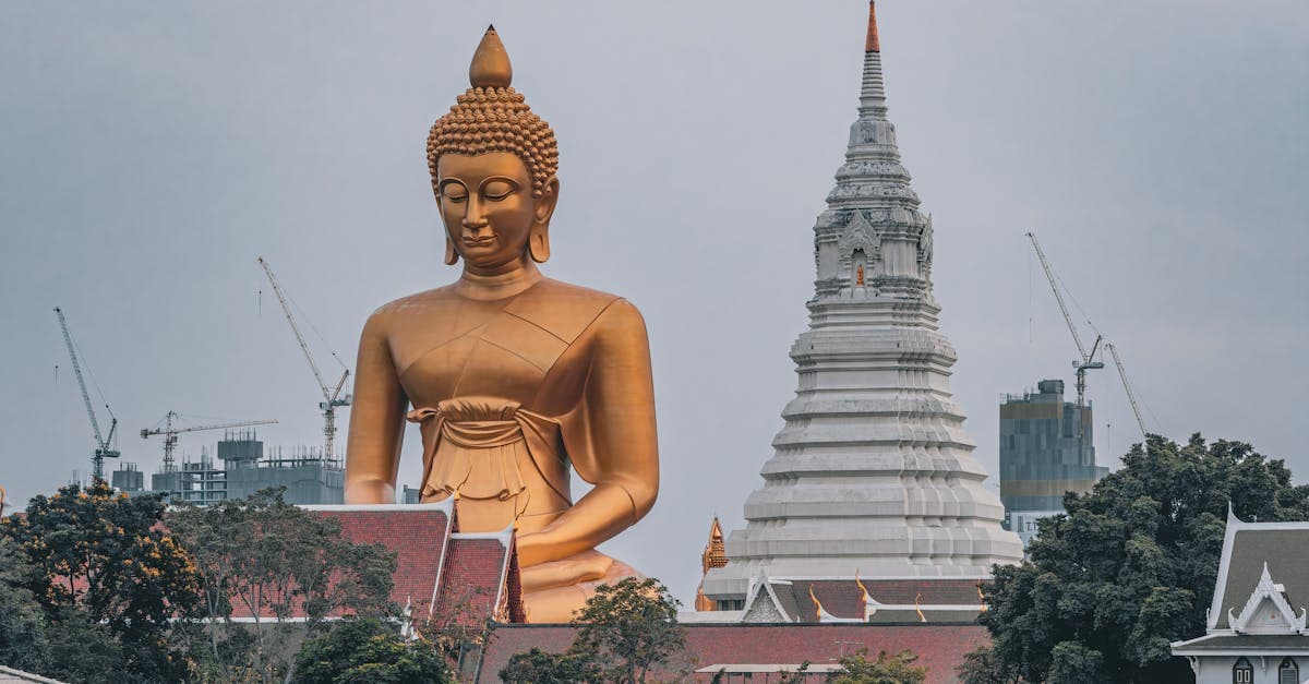 Majestätische goldene Buddhastatue neben einem Tempel in Bangkok – heiliger Ort beim Thailand Urlaub
