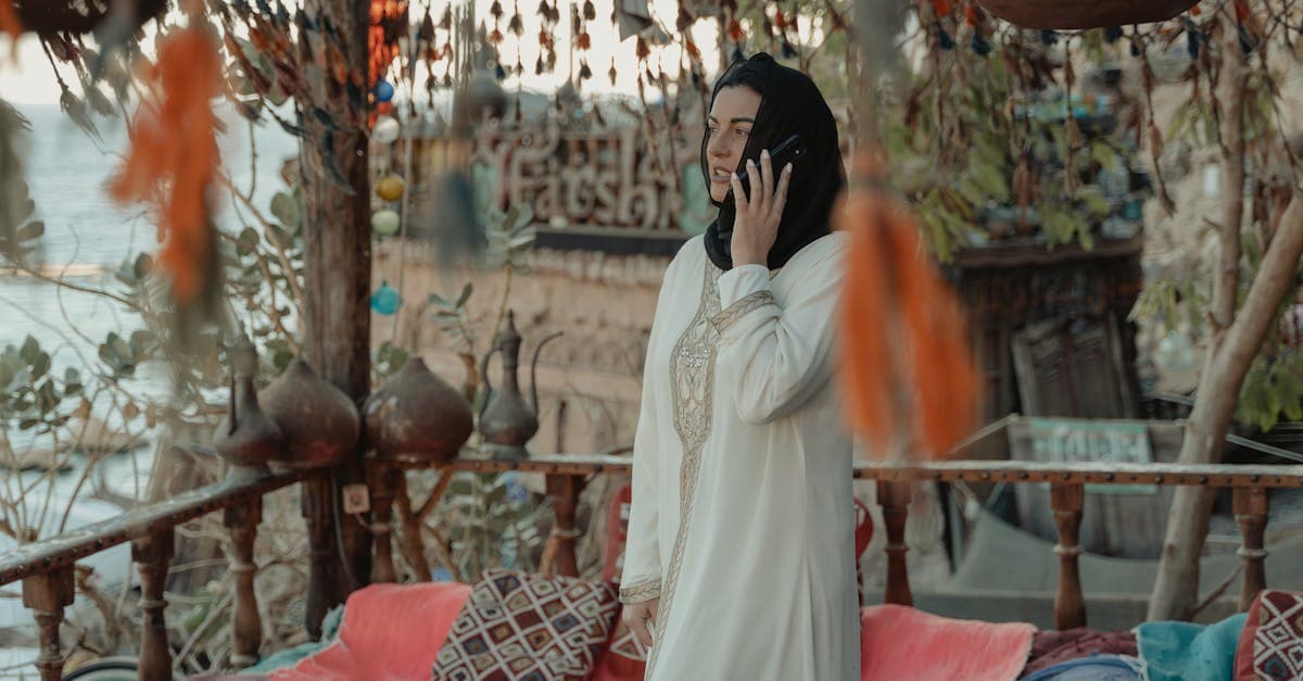 Kvinde med hijab taler i mobiltelefon i smukt udsmykket egyptisk omgivelse