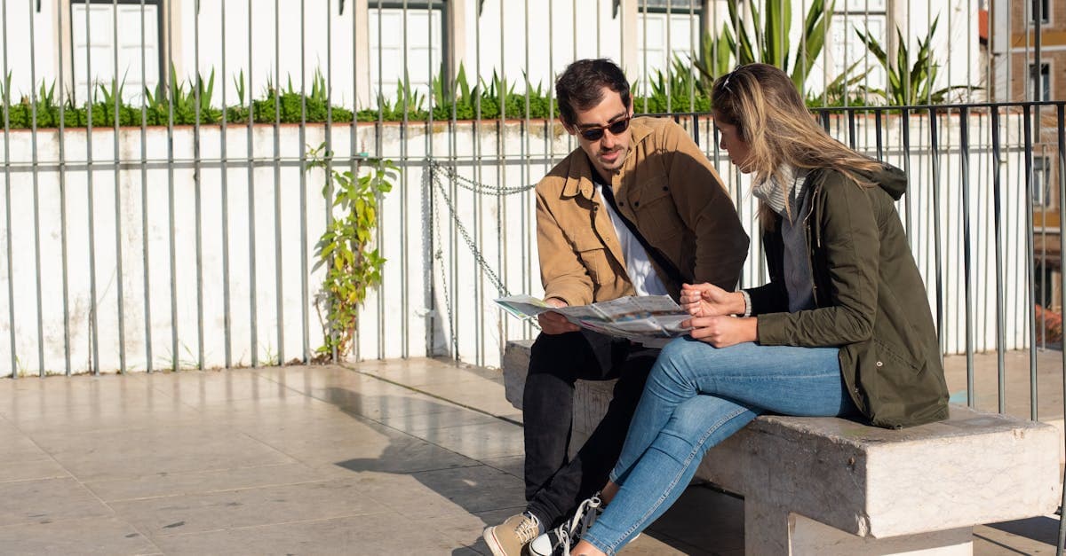 South African tourists reviewing their 2-week europe itinerary on a bench in sunny weather