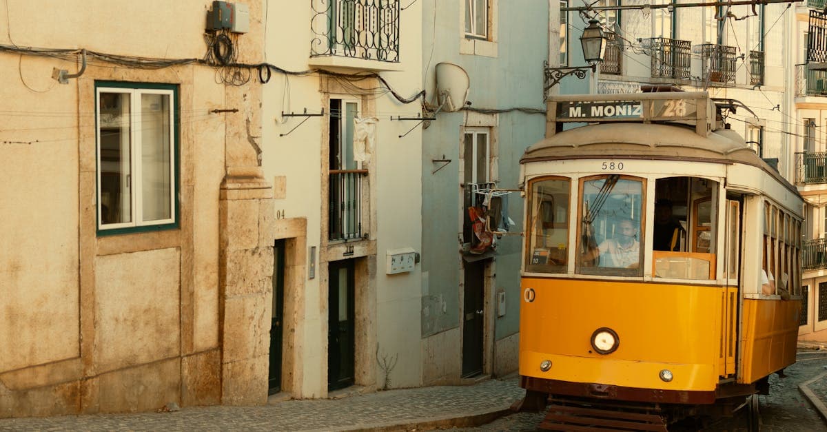 Tram jaune iconique numéro 28 traversant les ruelles pavées de Lisbonne, symbole de la ville.