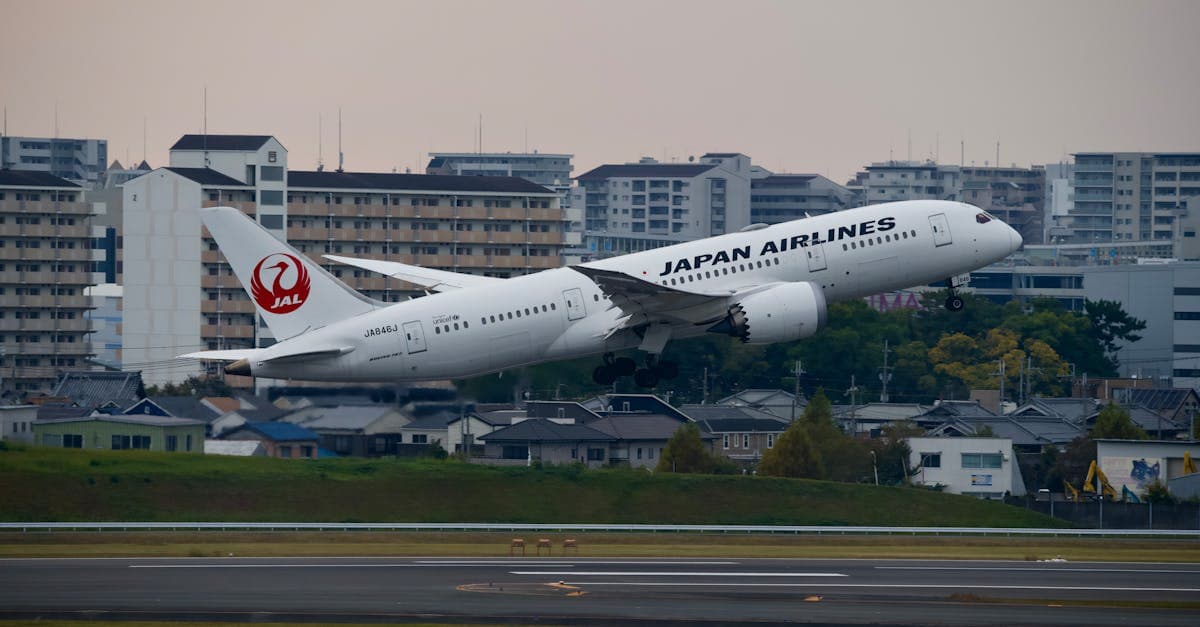 Japan Airlines Boeing 787 taking off from an urban airport during the cheapest season for flights to Japan