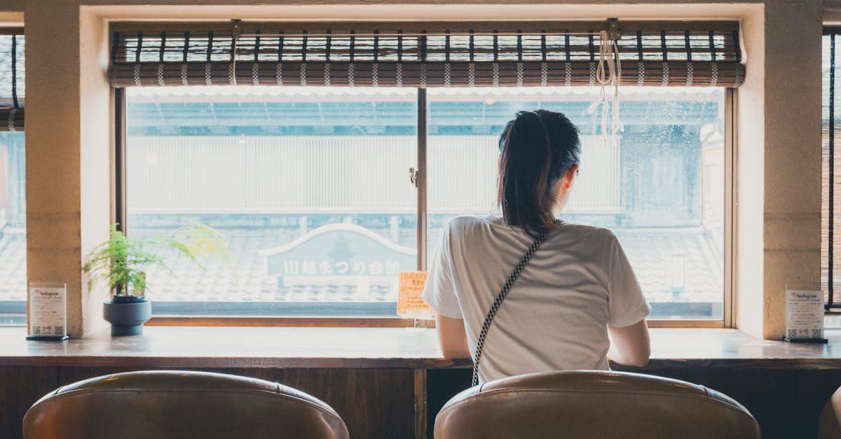 川越の歴史的な街並みが見えるカフェで窓外を眺める女性、一人旅の平均費用と旅の楽しみ方