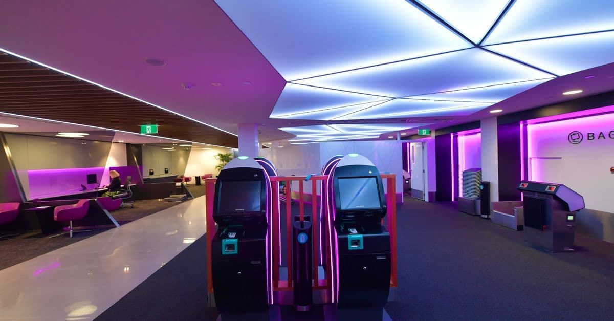 Modern Sydney Airport lounge with automated check-in kiosks and contemporary lighting for travellers.