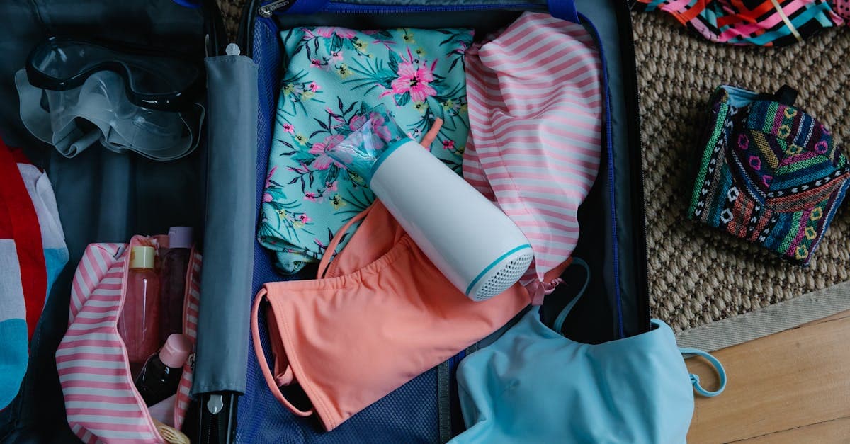 Packed suitcase with swimwear, goggles, and health essentials covering toiletries on a travel packing list.