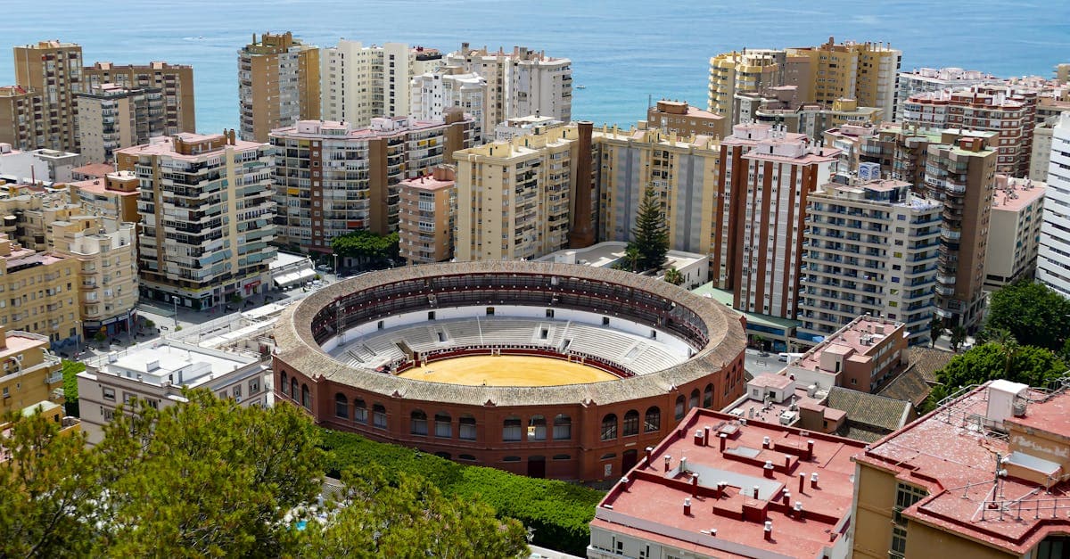 Flygfoto över La Malagueta-arenan i Málaga med stadens kustlinje och det blå Medelhavet.