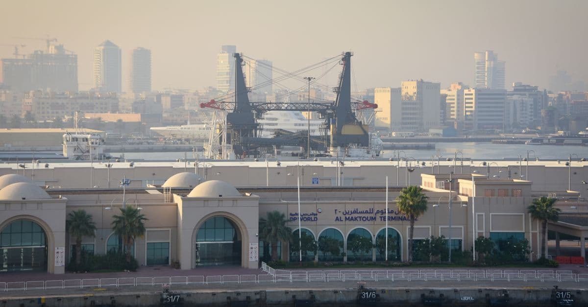 Blick auf das Al-Maktoum-Terminal am Flughafen Dubai mit Baukränen und der Skyline im Hintergrund.