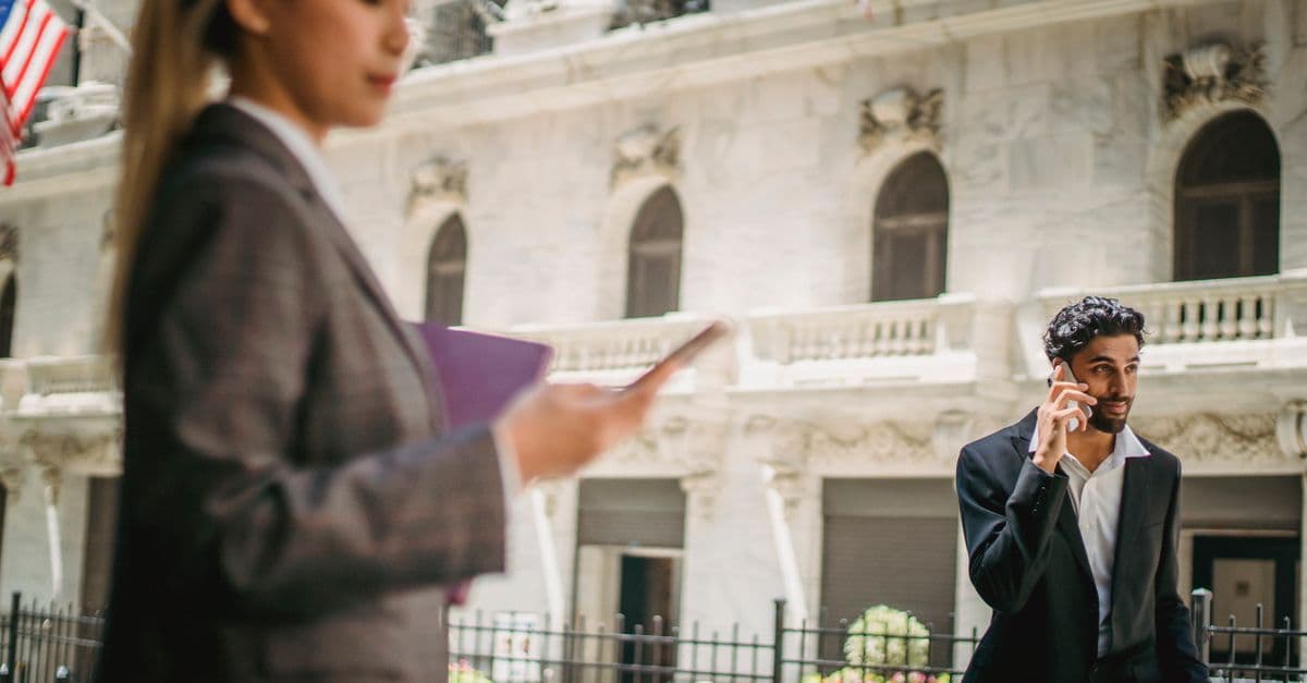 Business professionals using smartphones outdoors, staying connected through a mobile virtual network operator.
