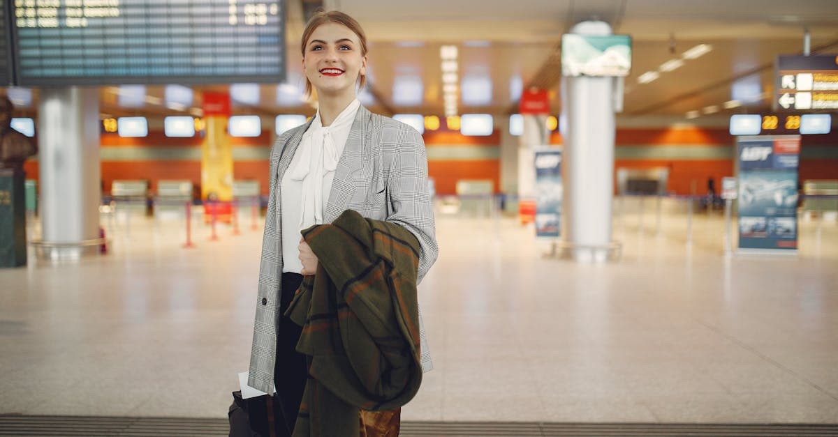 Professional businesswoman at a modern airport terminal checking mobile network coverage for international roaming in New Zealand.
