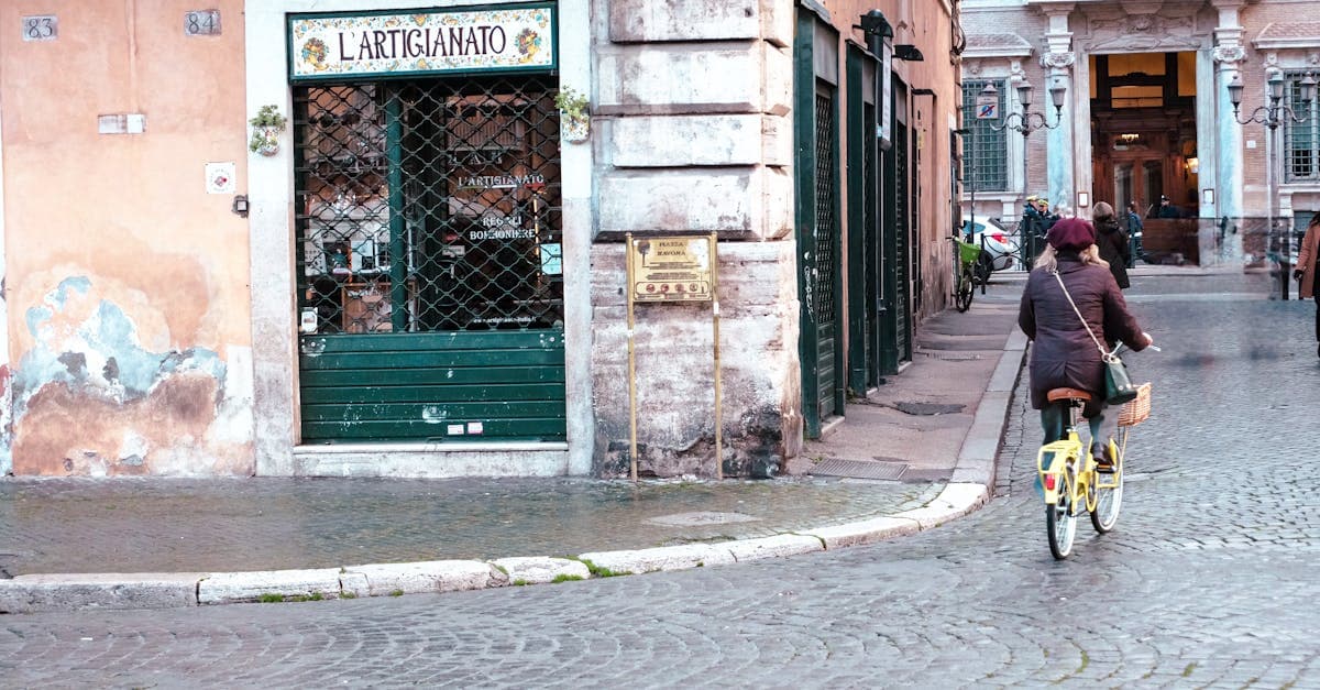 Persona en bicicleta recorriendo una calle adoquinada de Roma, explorando barrios auténticos lejos de los restaurantes trampa para turistas.