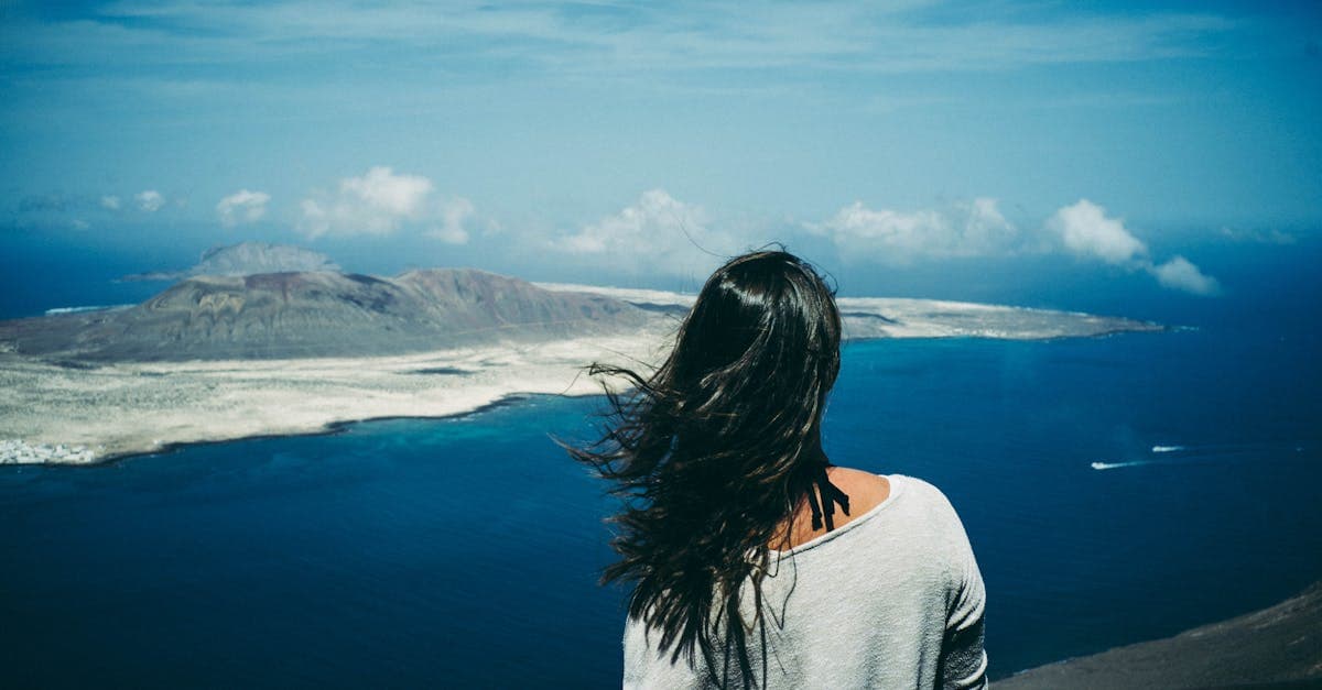 Woman at a hilltop viewpoint in Teguise gazing at the ocean, enjoying free things to do in Lanzarote