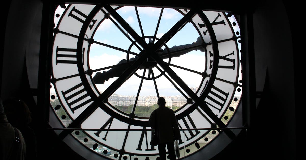 Silhouette framed inside the Musée d'Orsay clock overlooking Paris skyline, perfect during the best time to visit for festivals