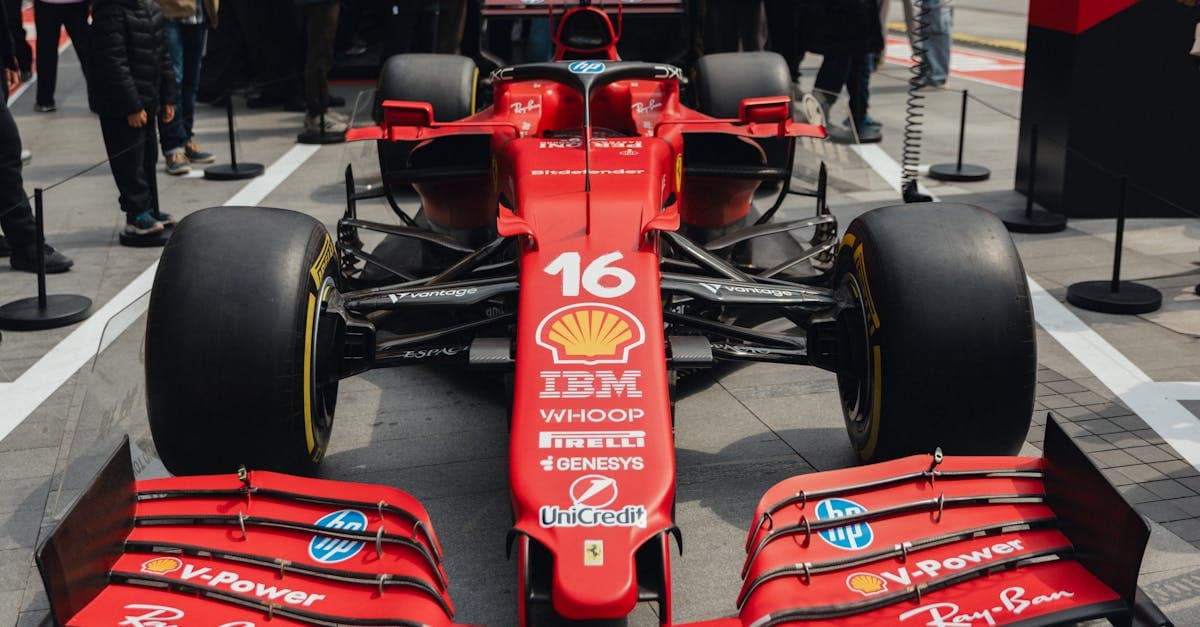 Ferrari rossa esposta al pubblico durante un evento f1 2026, con tifosi attratti dalle nuove monoposto.