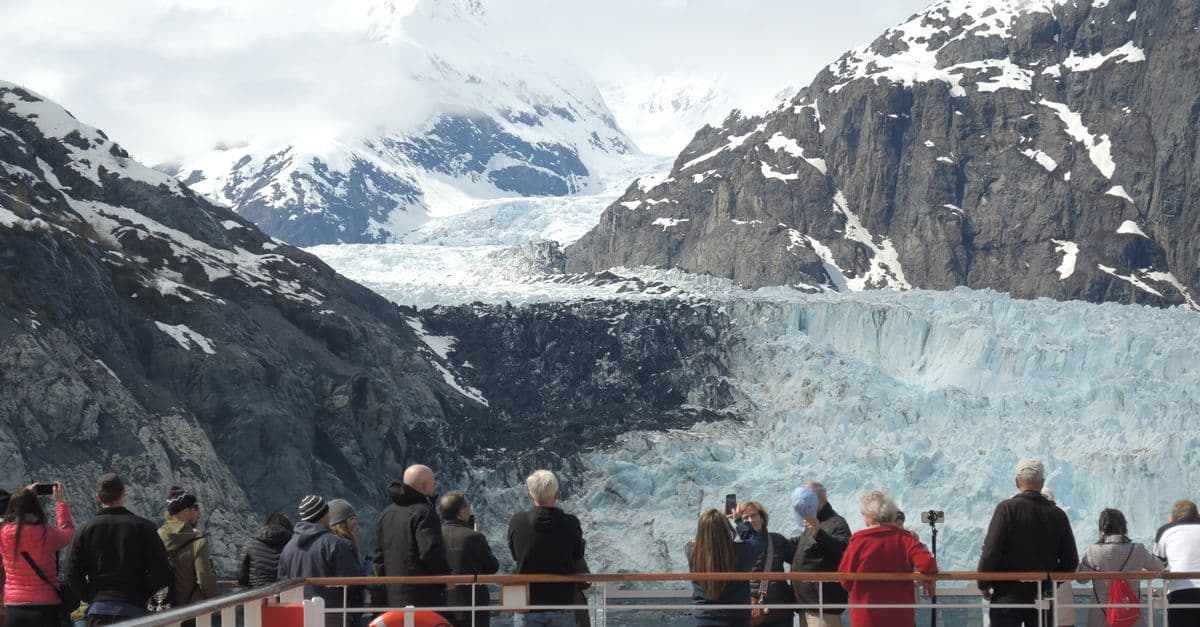 Des touristes admirent un glacier depuis le pont d'un navire de croisière en Alaska depuis Vancouver.