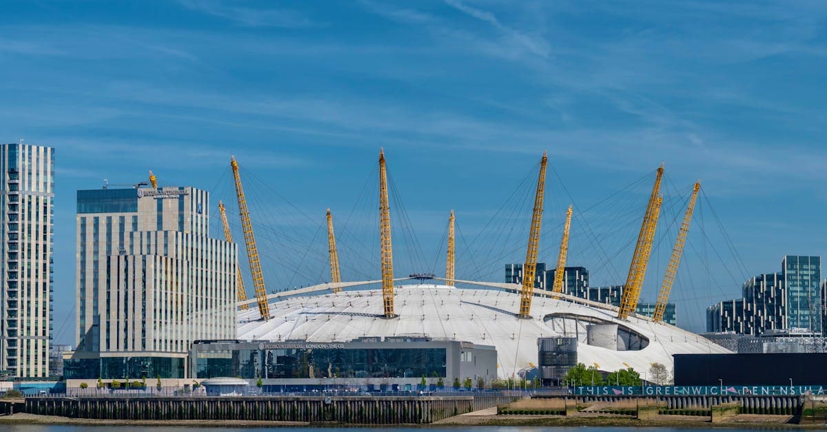 The O2 Arena and London city skyline reflected along the River Thames on a clear day