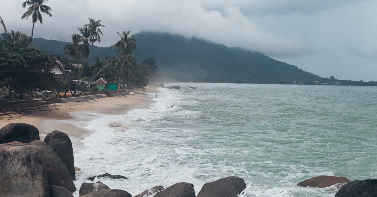 Tropischer Strand auf Koh Samui mit brechenden Wellen und üppigem Grün – entgegengesetzte Regenzeit zu Phuket