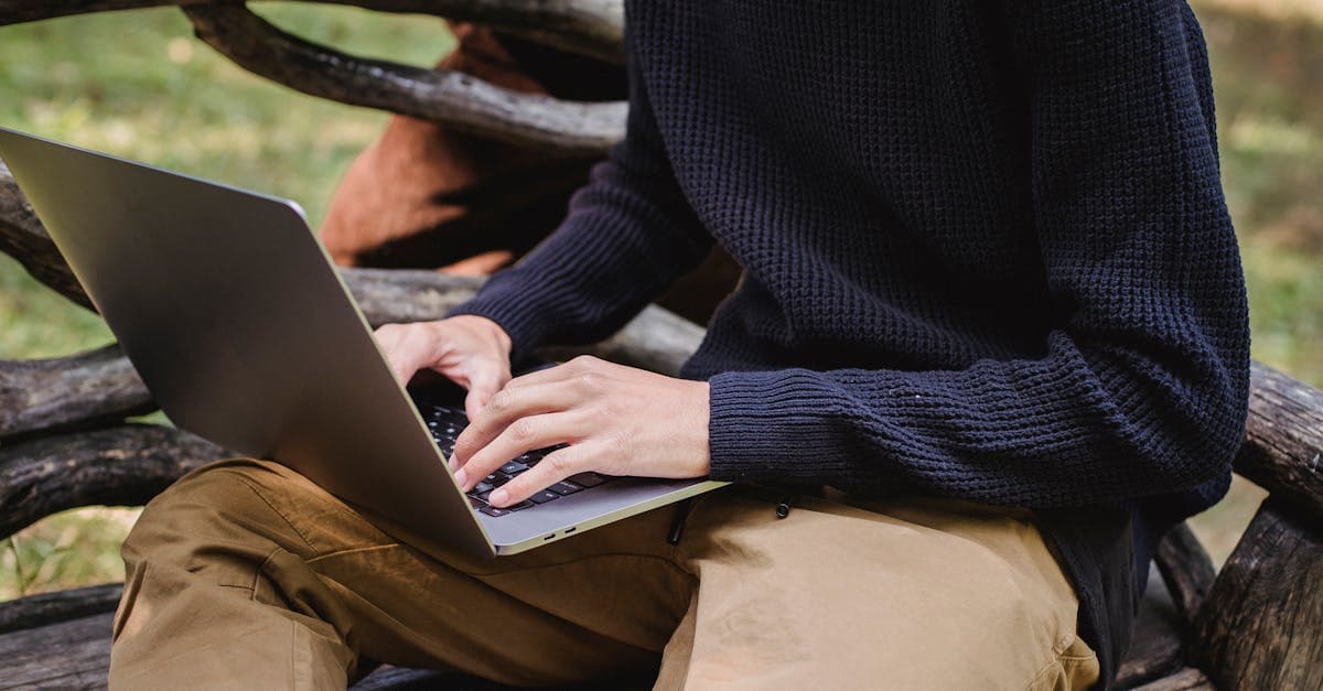 Traveller on a park bench using a laptop with portable wifi while exploring Europe after Brexit
