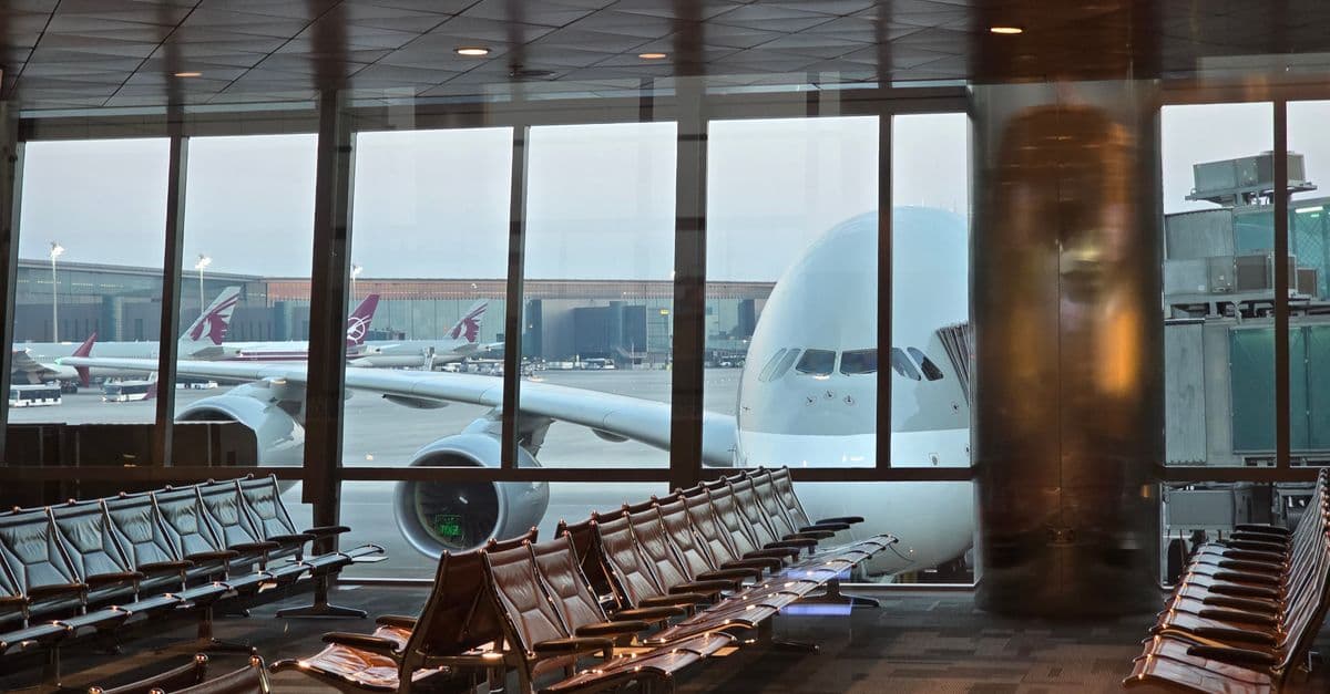 Passagierflugzeug am Doha Flughafen parkt am Gate, davor ein leerer Wartebereich für Reisende.