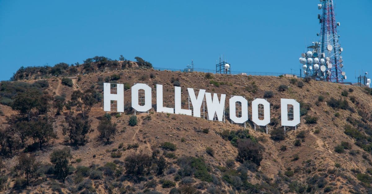 Iconic Hollywood Sign on a sun-drenched Los Angeles hillside, a must-see landmark for Perth travellers flying in.