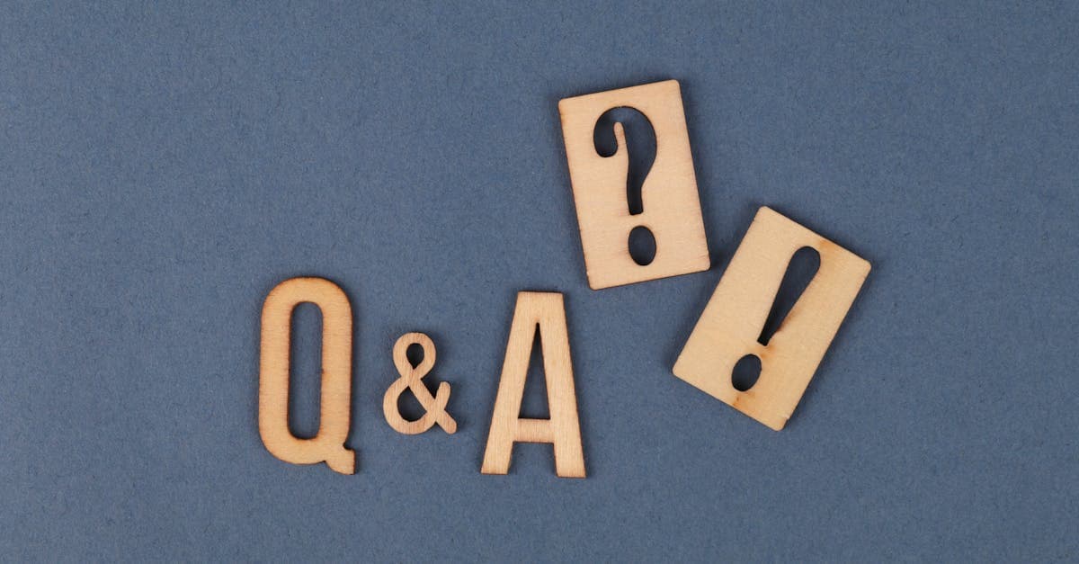 Flat lay of wooden Q&A letters with punctuation marks on a gray background.