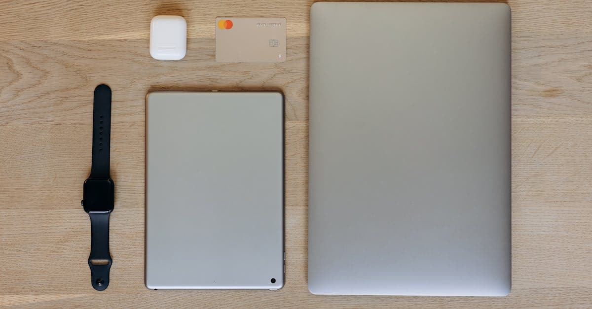 Laptop, tablet i smartwatch na drewnianym stole — eSIM w różnych urządzeniach mobilnych