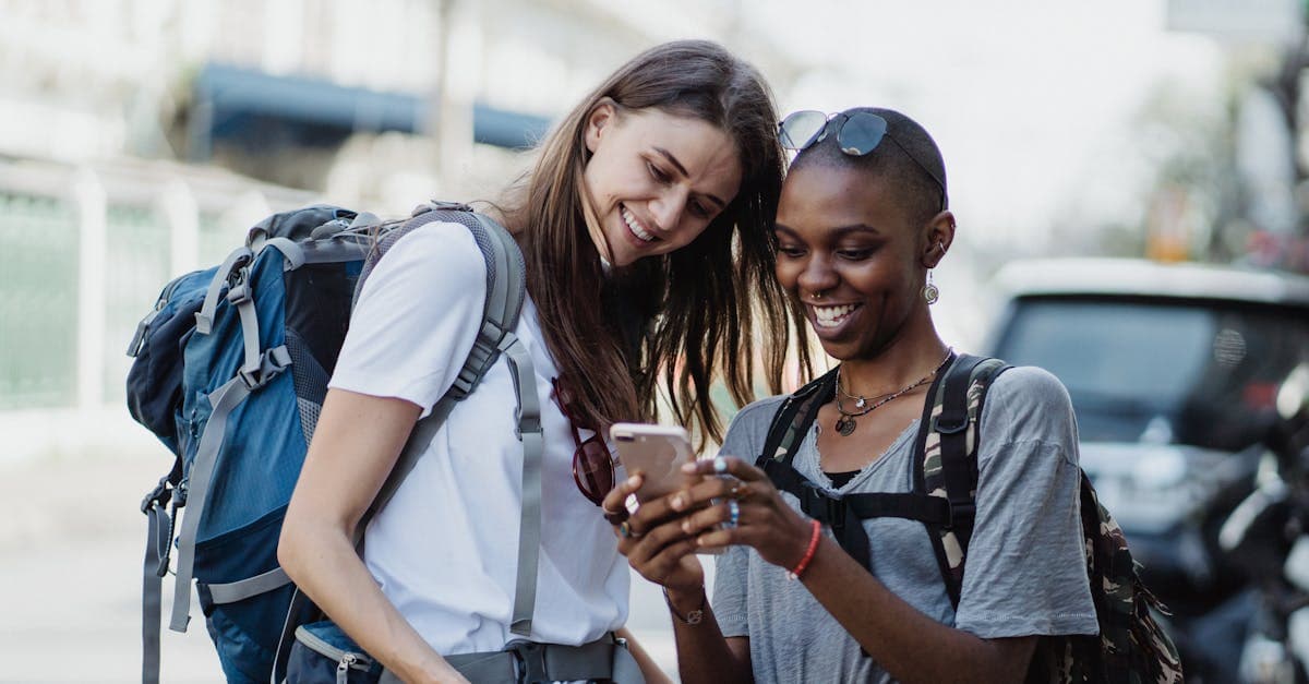 Two international students with backpacks exploring London streets while staying connected with mobile data.