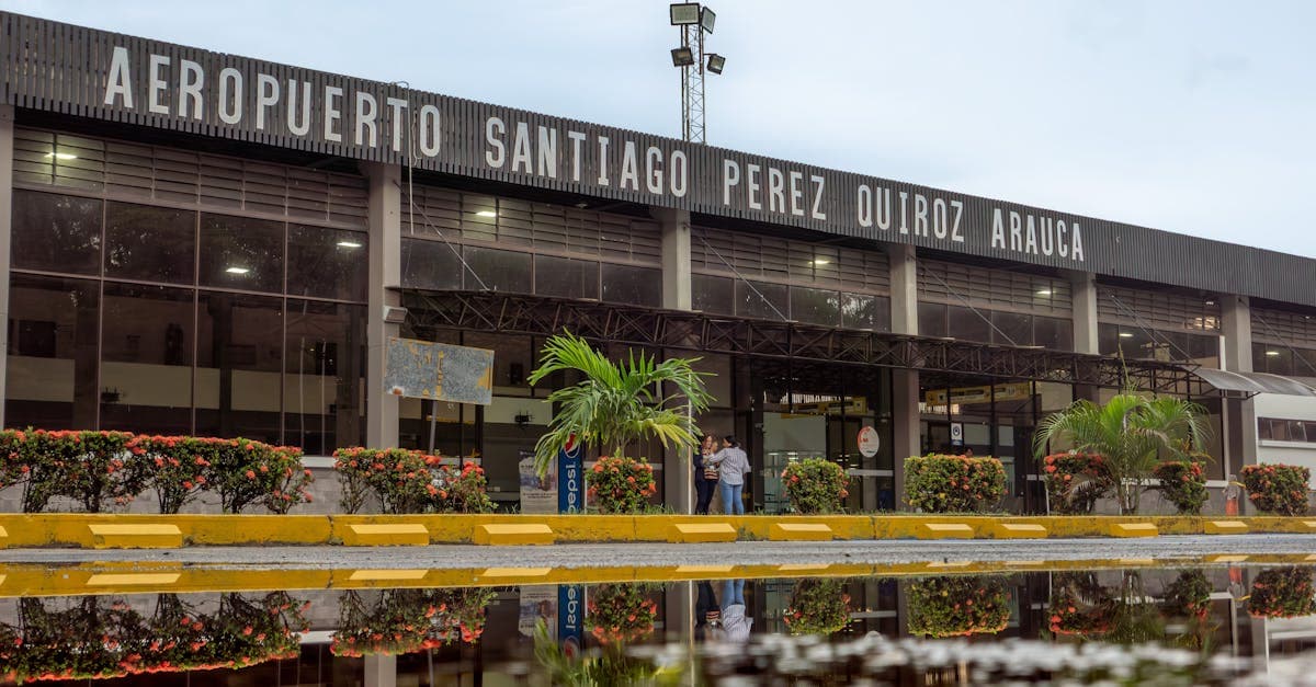 Vista exterior del aeropuerto colombiano con reflejo en charco, esencial para quienes planean vuelos a Colombia desde México