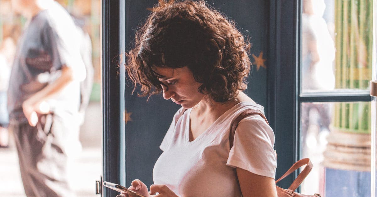 旅先の窓辺でスマホを操作する女性、travel eSIMやポケットWiFiで快適につながる一人旅