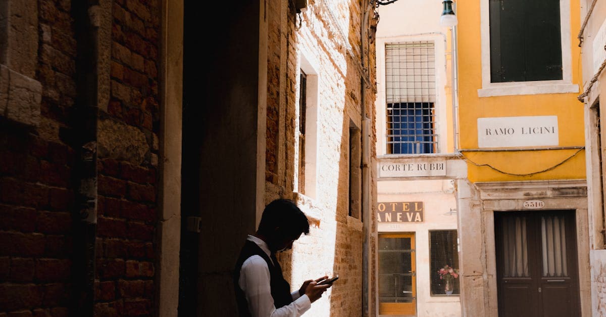 Silhouette di uomo che usa il telefono in un vicolo colorato con la migliore sim dati illimitati