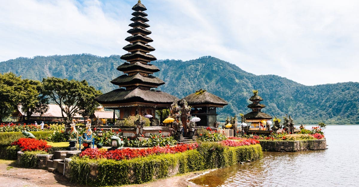 Temple Ulun Danu Beratan de Bali entouré de montagnes verdoyantes, emblème de la haute saison touristique en juillet-août