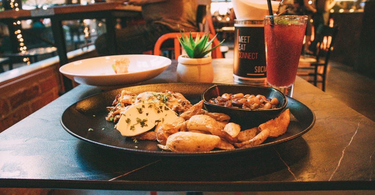 Gewürzte Kartoffeln und ein kühles Getränk auf einem Tisch im DO & CO Restaurant Stephansplatz.