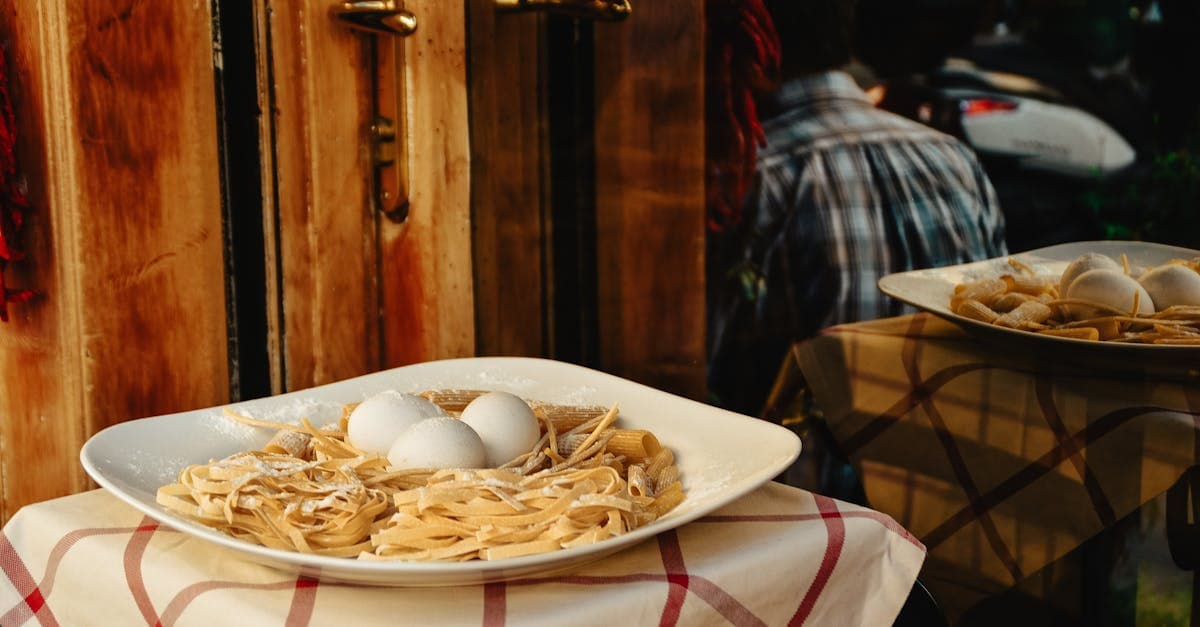 Plato de pasta fresca con huevos expuesto a la entrada de un restaurante, símbolo de la cocina romana tradicional.