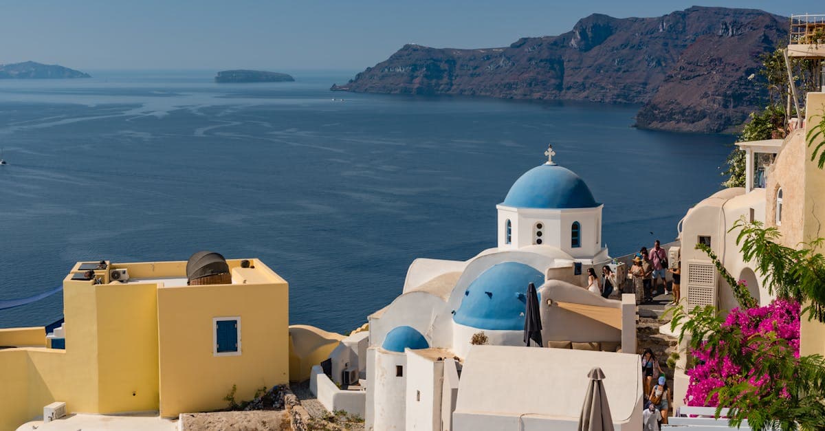 Ikoniska blå kupoler i Fira på Santorini med utsikt över Egeiska havet under sommaren.
